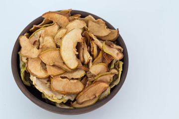 Apple quince chips in a brown clay bowl isolated healthy food