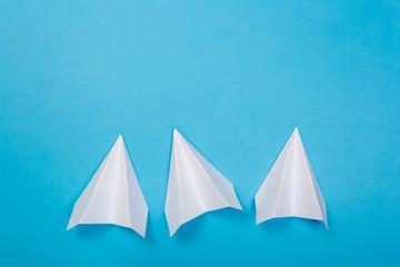 white paper airplane on a navy paper background