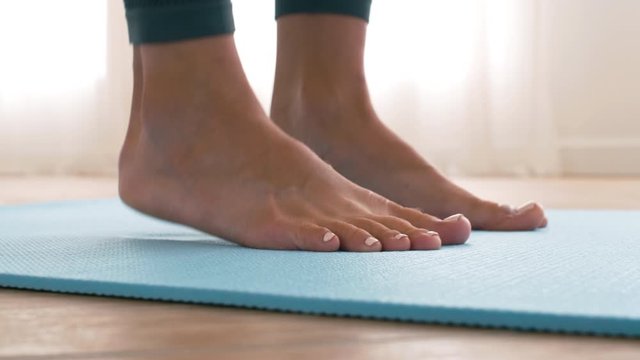 Close up shot of female feet standing on toes on gym mat