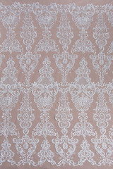 Texture lace fabric. lace on white background studio. thin fabric made of yarn or thread. a background image of ivory-colored lace cloth. White lace on beige background.