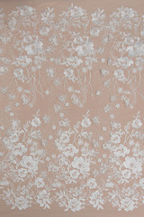 Texture lace fabric. lace on white background studio. thin fabric made of yarn or thread. a background image of ivory-colored lace cloth. White lace on beige background.