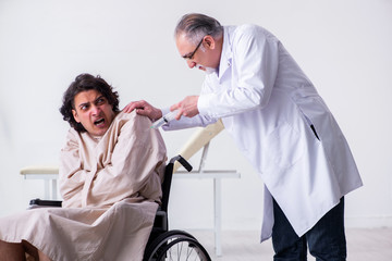 Old male doctor psychiatrist and patient in wheel-chair