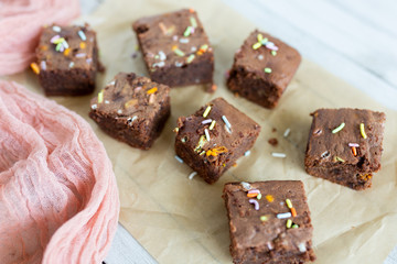Banana brownies with multi colored sprinkles, crinkled parchment paper, pink raw silk fabric