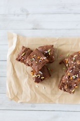 Top view of banana brownies with multi colored sprinkles, crinkled parchment paper