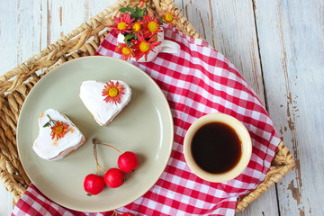 Valentine`s Day breakfast two heart honey cakes on ceramic plate with red fabric and red apples and red flowers on white wooden table,top view,romantic morning food