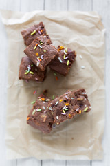 Top view of banana brownies with multi colored sprinkles, crinkled parchment paper