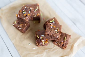 Top view of banana brownies with multi colored sprinkles, crinkled parchment paper