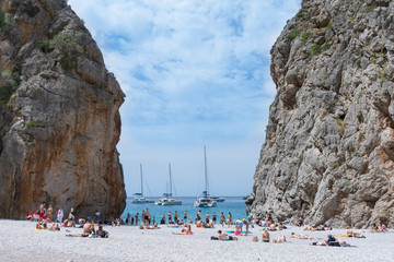 Obraz premium People relax on the beach in the Bay Sa Calobra.