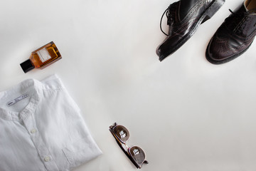 Male outfit set on white background. Shirt and shoe. Close-up, top view 