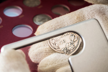 Numismatist inspects old collectible Finnish coins