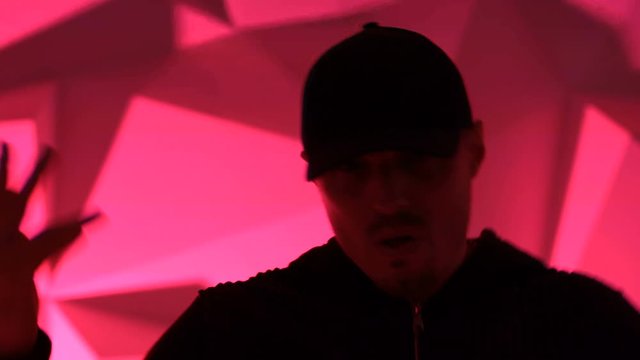 Rapper man dancing to the music. Silhouette on a dark red background