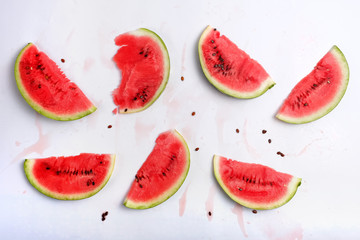 Watermelon slices, seeds and juice stains afer eating on white background