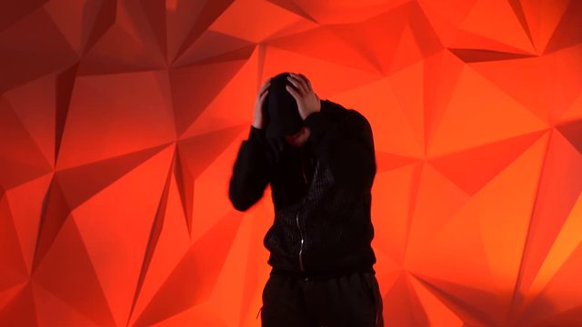 Rapper man dancing to the music. Silhouette on a dark red background