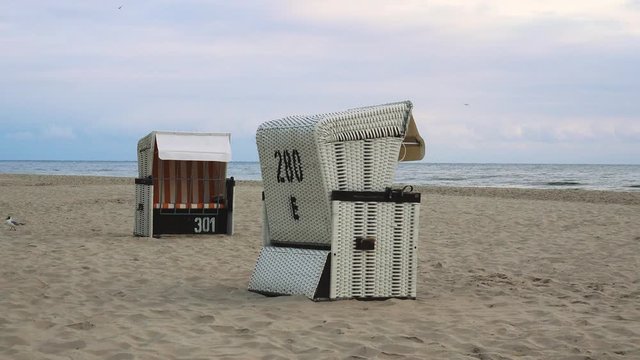 leerer Strand mit Strandk&ouml;rben und schlechtem Wetter