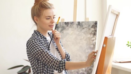 Happy lovely girl cleans off unnecessary paint. Fine art concept