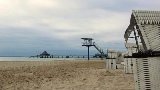 leerer Strand mit Strandk&ouml;rben und schlechtem Wetter