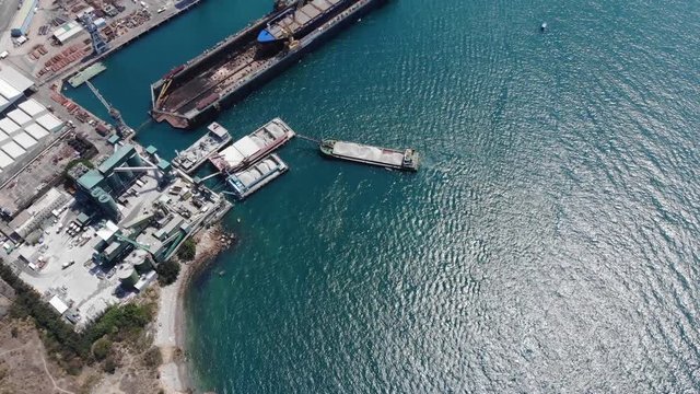 Bulk cargo ship at industrial wharf, factory facility near, dry dock watercraft stay close, top down aerial shot. West side of Tsing Yi island, docks at reclaimed land area