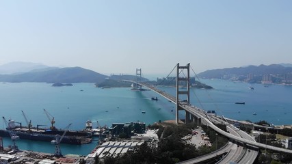 Tsing Ma bridge and industrial area at reclaimed land of west shore at Tsing Yi island. Nice aerial view, camera fly left and forward, changing perspective