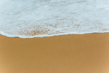 Fototapeta na wymiar Soft Blue ocean wave on sandy beach. tropical white sand With the sea at the corner.