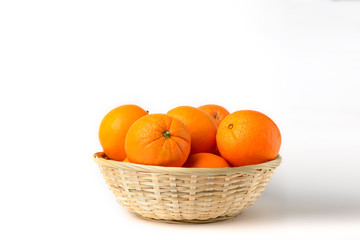 Fresh juicy oranges in wooden basket on white background