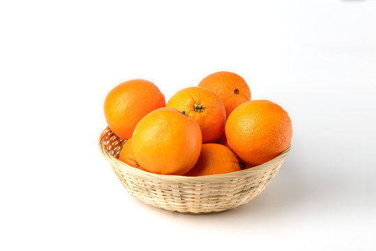 Fresh juicy oranges in wooden basket on white background