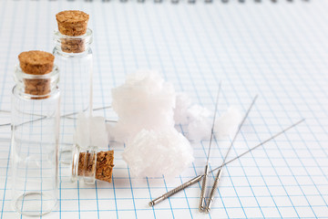 Fototapeta premium Medical Glass container with cork stopper end Needles for medical acupuncture are on the notebook.