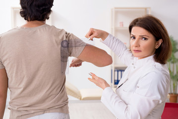 Female doctor checking patient's joint flexibility with goniometer