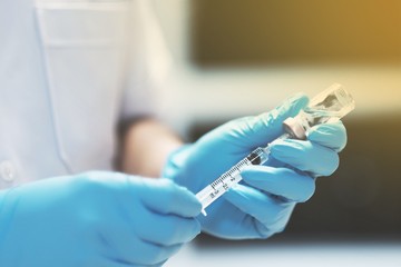 Nurse holding syringe and vaccine for injection