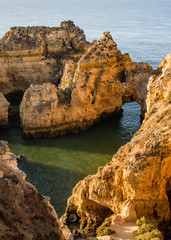 Vacation in Algarve - View from above of colourful bay, arches and cliffs of Ponta da Piedade. The rock formations and cliffs rising from the turquoise waters of the sea