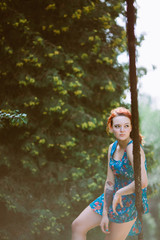 Young beautiful redhead woman on the rope bridge.