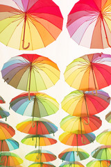 Fototapeta na wymiar Bright colorful umbrellas umbrellas under the city street in the sky. Street decoration