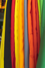 bright textile fabric hanging up in a market in bali