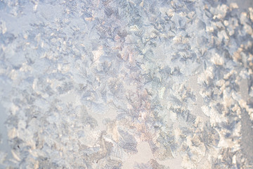 Ice patterns on winter glass of window, with the light seen through it. Horizontal banner....