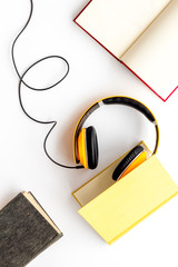 workplace with books and headphones on white background flatlay