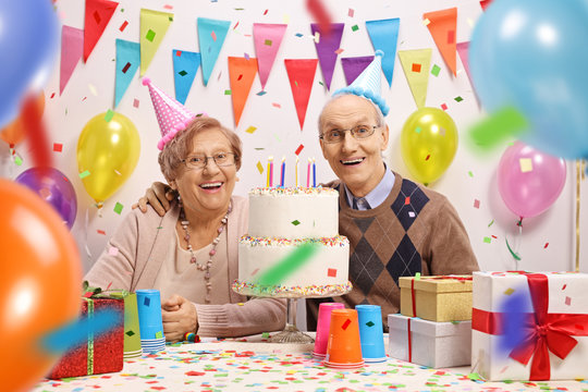 Happy senior couple with a cake at a birthday
