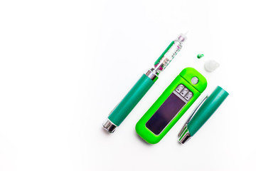 Diabetes pen injection needle and blood glucose meter isolated on white