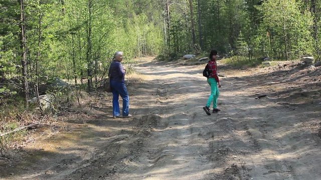 An elderly woman and granddaughter went for a walk in the forest