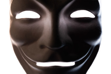 Dark mask isolated on white. Close-up. Smile symbol of an anonymous hacker. Shooting a subject in a dark key.
