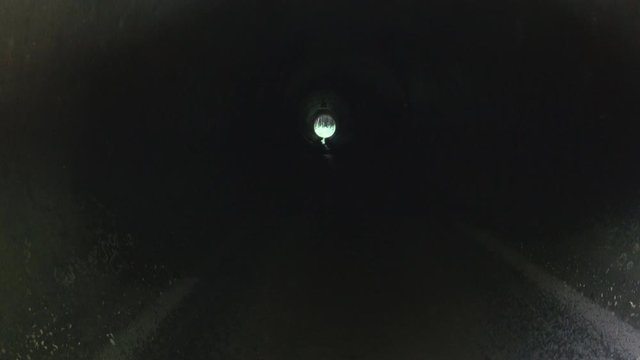 Inside the drain pipe. Dry culvert under the highway in summer