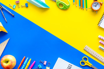 Creative mess on student's desk on yellow and blue background top view mock-up