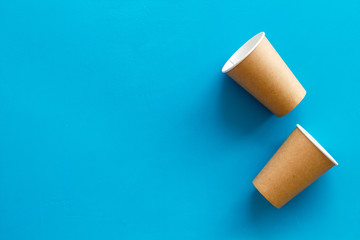 Paper cups for coffee to go on blue background top view mockup