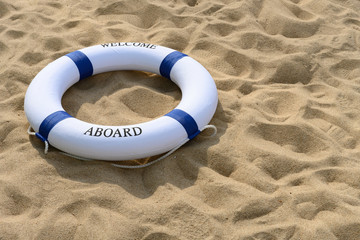 blue buoy on  sand with word of welcome aboard