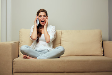 Obraz premium Woman sitting on sofa talking on mobile phone.