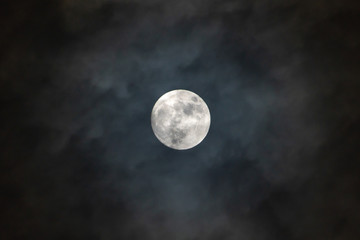 Fototapeta na wymiar Full moon on the dark night shining on the sky in cloudy day.