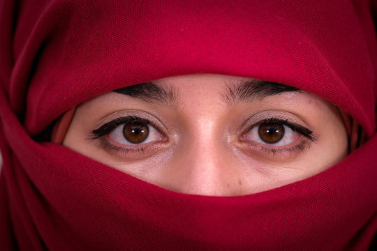 Muslim woman wearing red hijab veil, Afghan girl wear the burka or burqa, close up portrait photo
