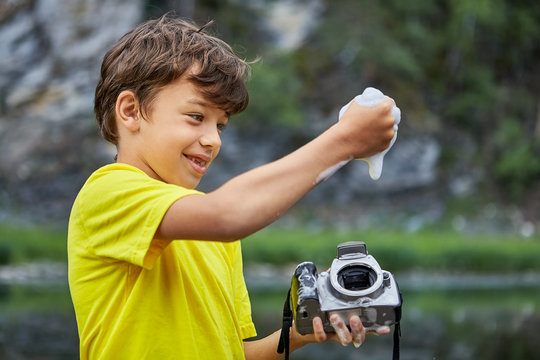 Boy cleans CMOS image sensor in digital camera.