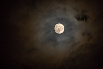 Naklejka na ściany i meble Full moon on the dark night shining on the sky in cloudy day.