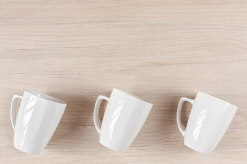 White ceramic cups on wooden background, image