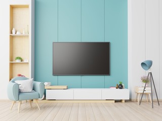 TV on the cabinet in modern living room with armchair on blue wall background.