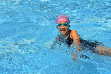 Fototapeta na wymiar プールで泳ぐ女の子